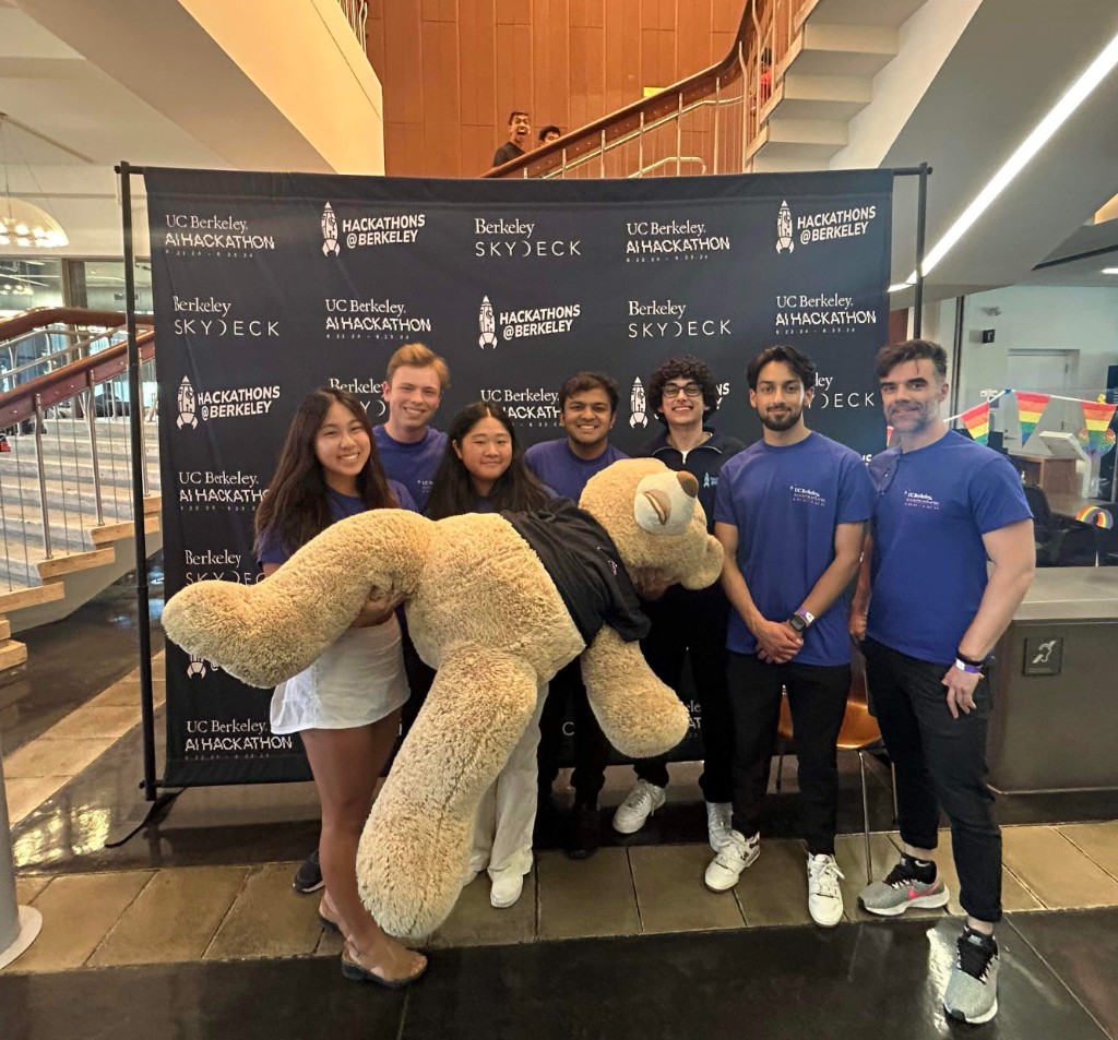Team holding the giant bear in front of the AI Hackathon 2024 step-and-repeat backdrop