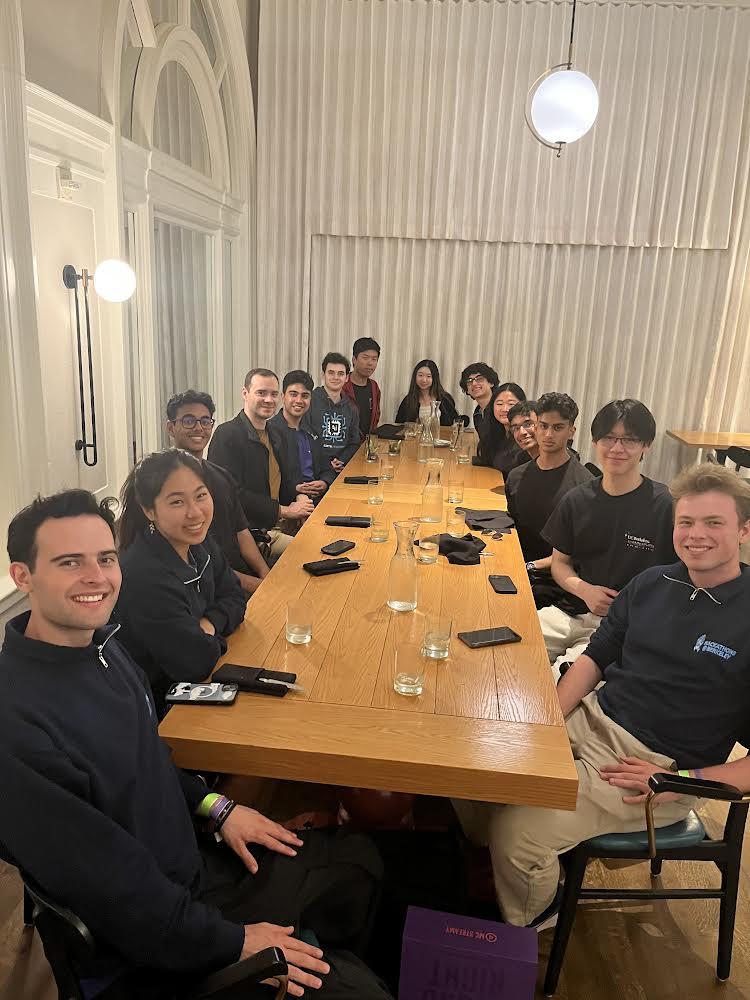 The AI Hackathon 2024 team gathered around a long dinner table