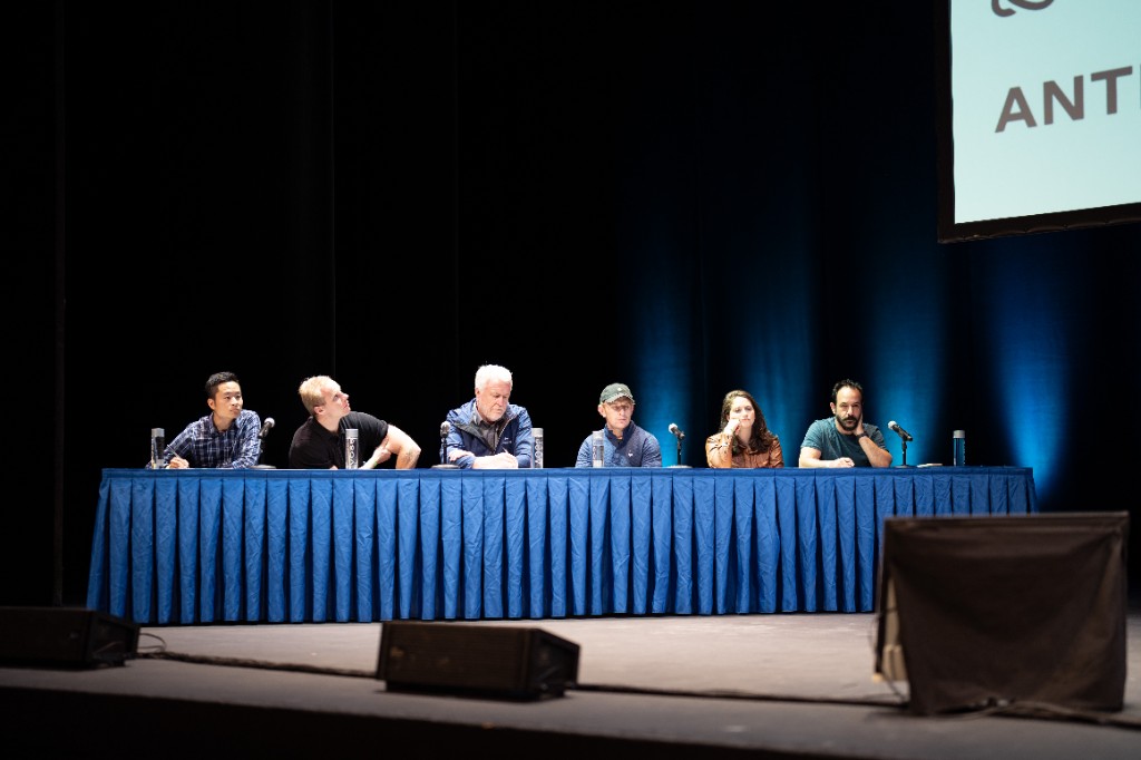Judges panel seated on stage during AI Hackathon 2025