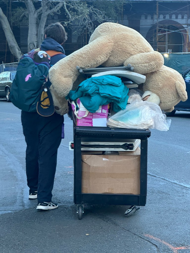 A teammate hauling the giant bear and supplies on a cart